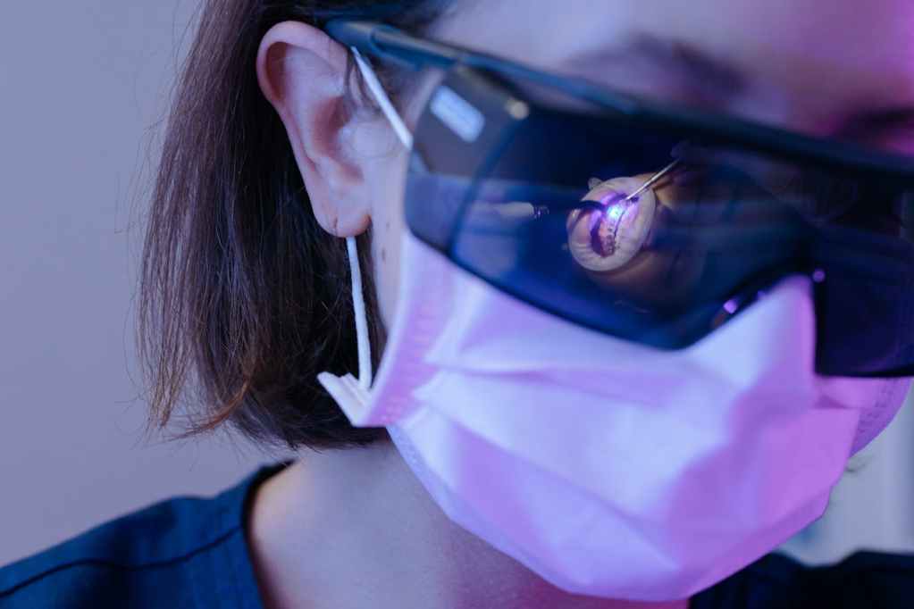 Dentist wearing protective glasses and face mask during dental procedure
