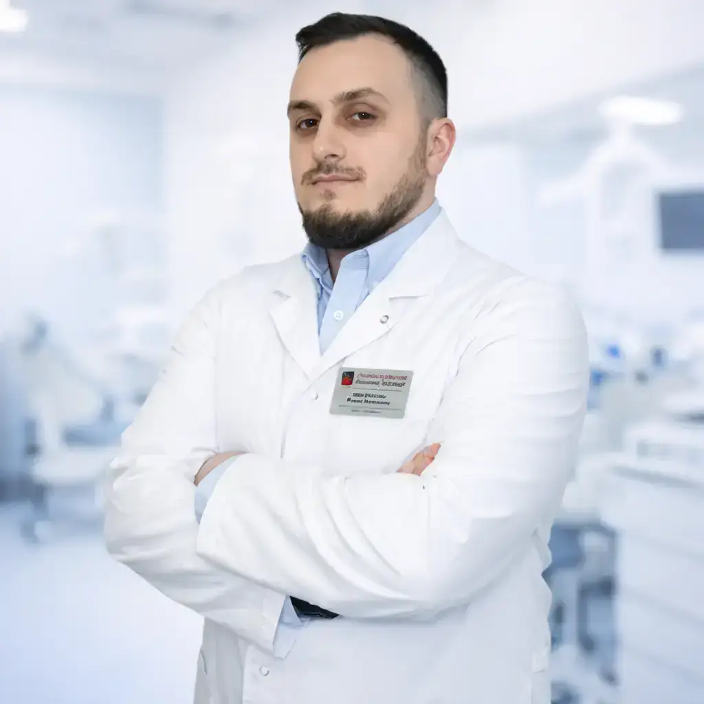 Доктор клиники ОртоКапа — врач-стоматолог Рахим Увайсович Джабраилов в белом халате на фоне стоматологической клиники